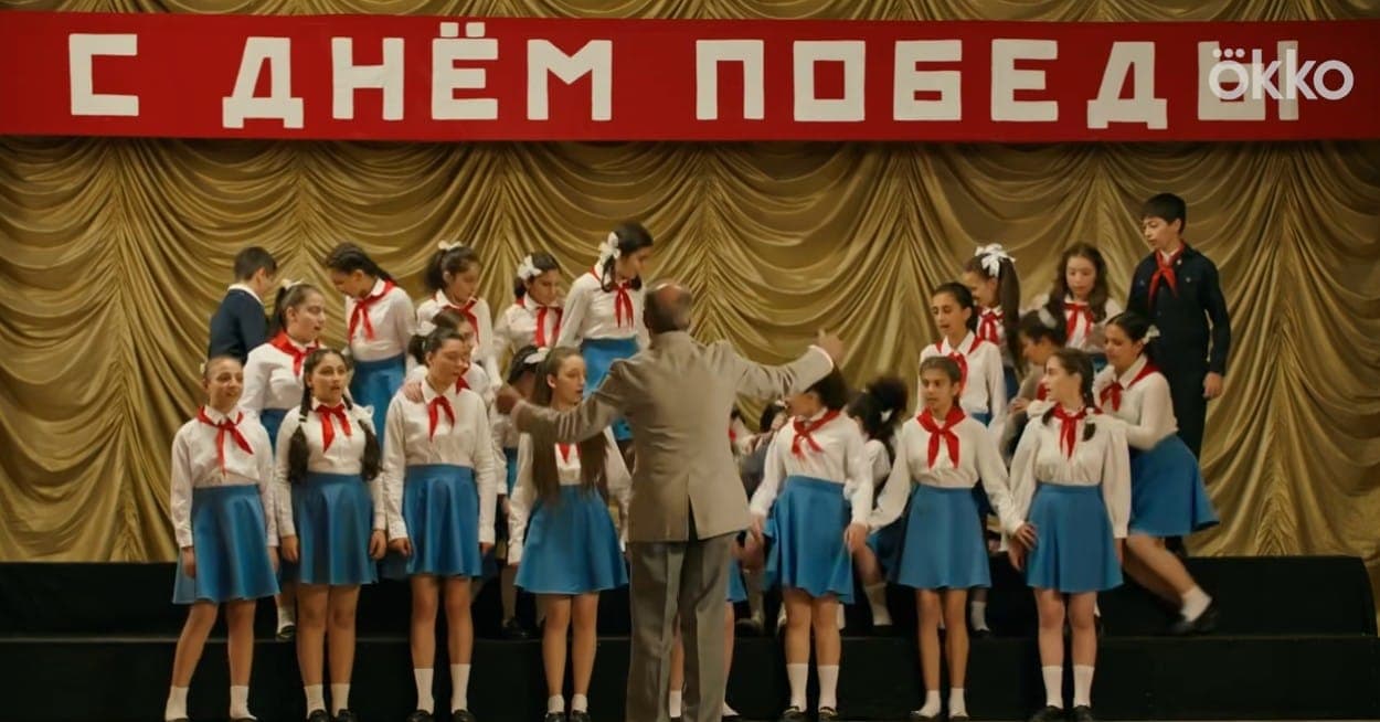 Лавка ломается - и весь хор летит вверх тормашками. Кадр из сериала "Манюня", 2021-2026, Okko, Солнце, СТС, Кинокомпания братьев Андреасян