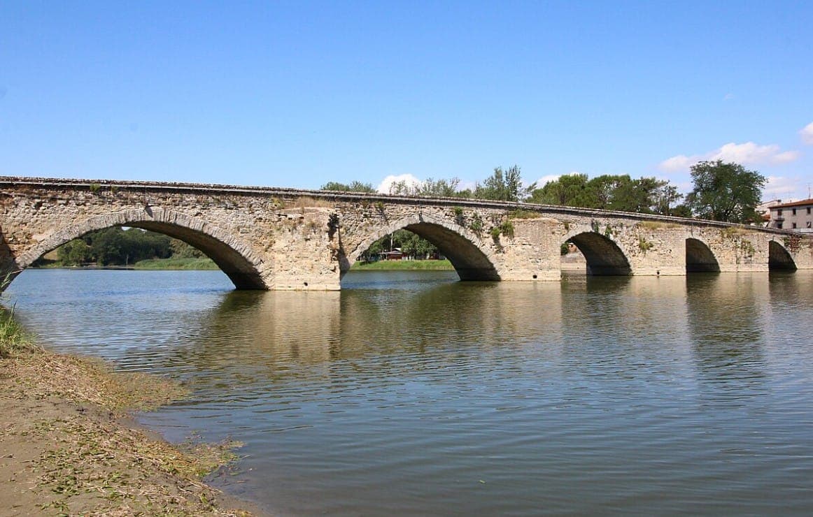 Арочный каменный мост с несколькими пролётами, перекинутый через реку в долине - подходит! Фото: LigaDue